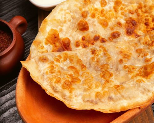 traditional-caucasian-gutab-kutab-gozleme-with-sumakh-yogurt-wooden-plate_114579-201